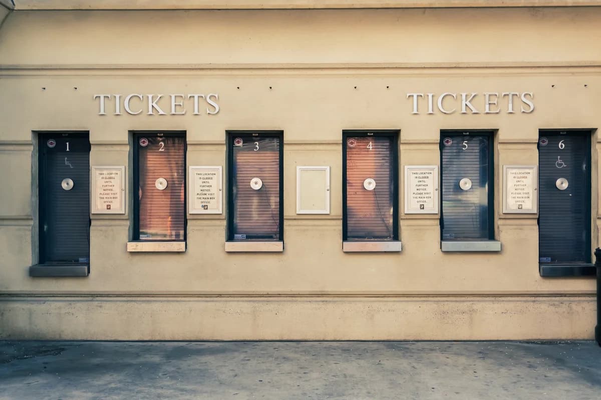 Six closed ticket booths numbered 1 through 6 on a beige wall with closure signs.