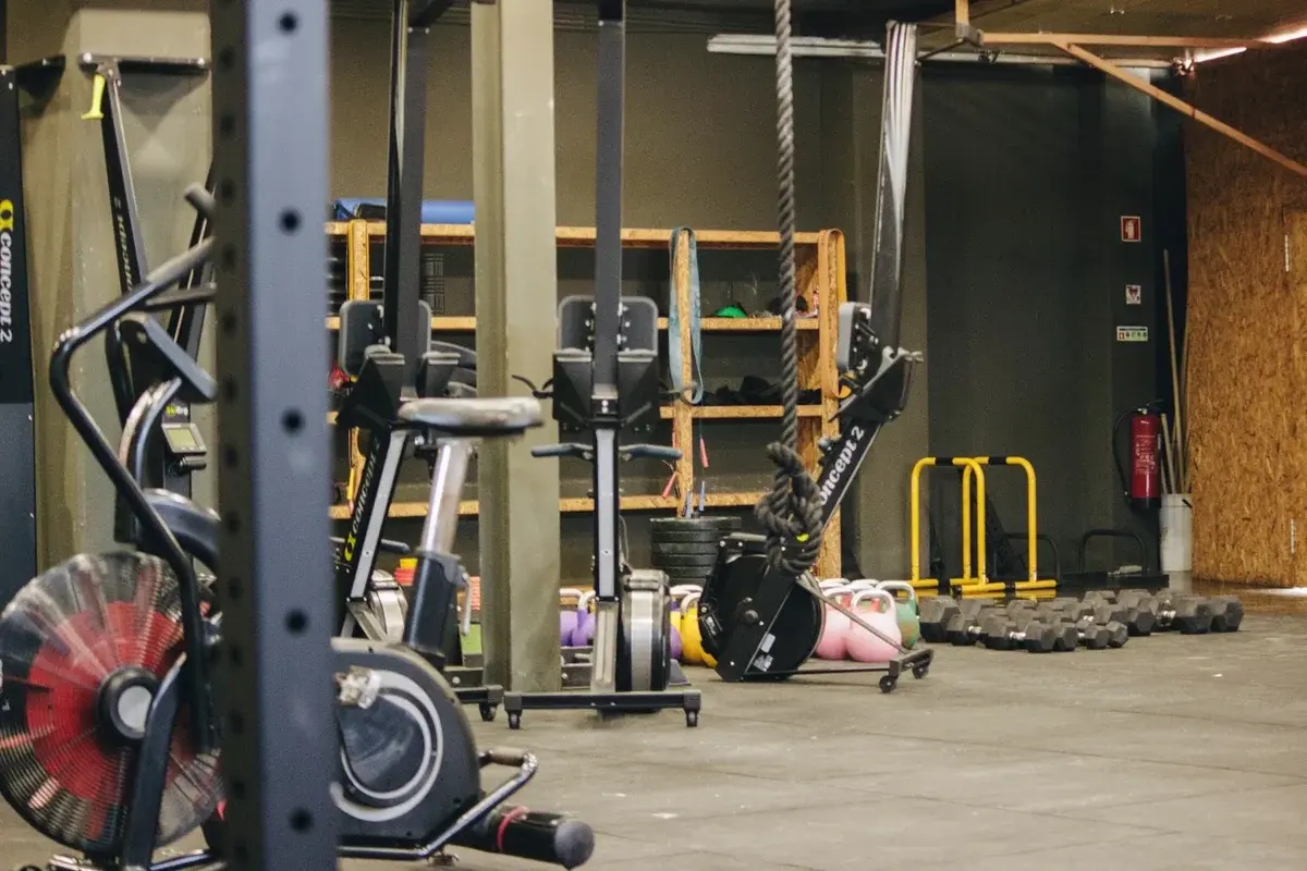 A well-equipped indoor gym with machines, weights, and kettlebells.