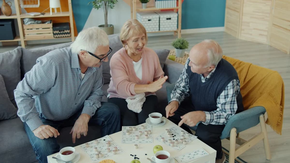 Three older adults playing a tabletop game in a cozy living room