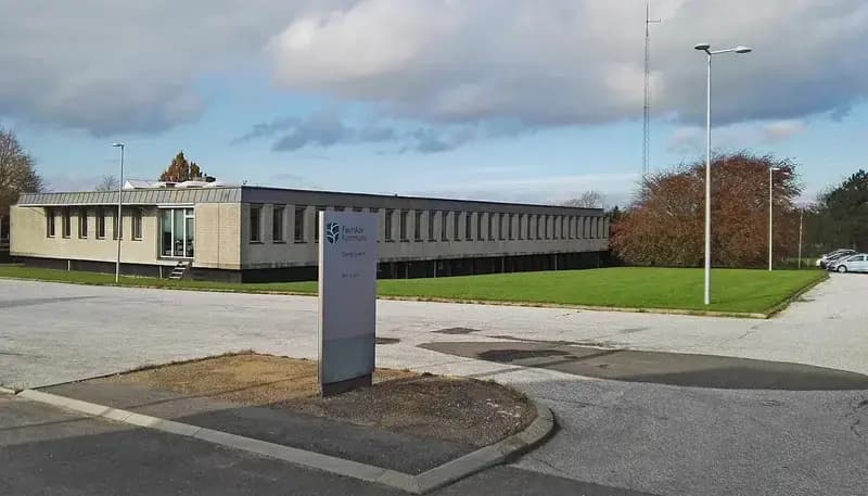 Exterior view of the Hvorslev Town Hall building and surrounding parking and green area
