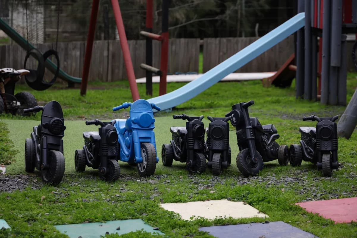 Outdoor play area with toy motorcycles and a slide