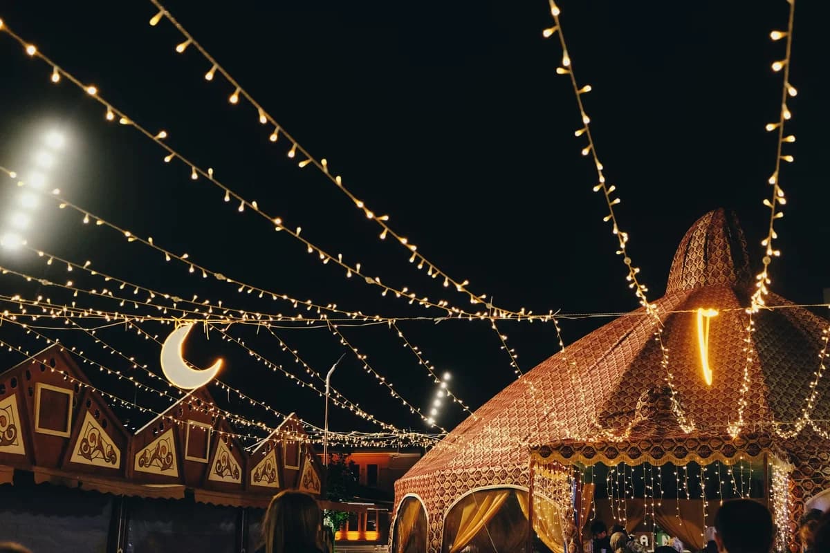 Night festival with decorative tents and hanging string lights.