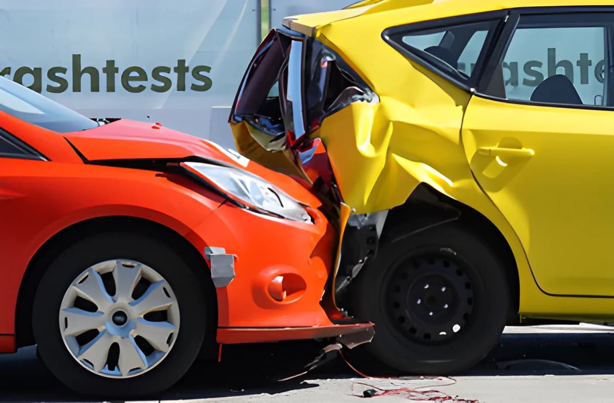 A red car and a yellow car smashed together in a collision.