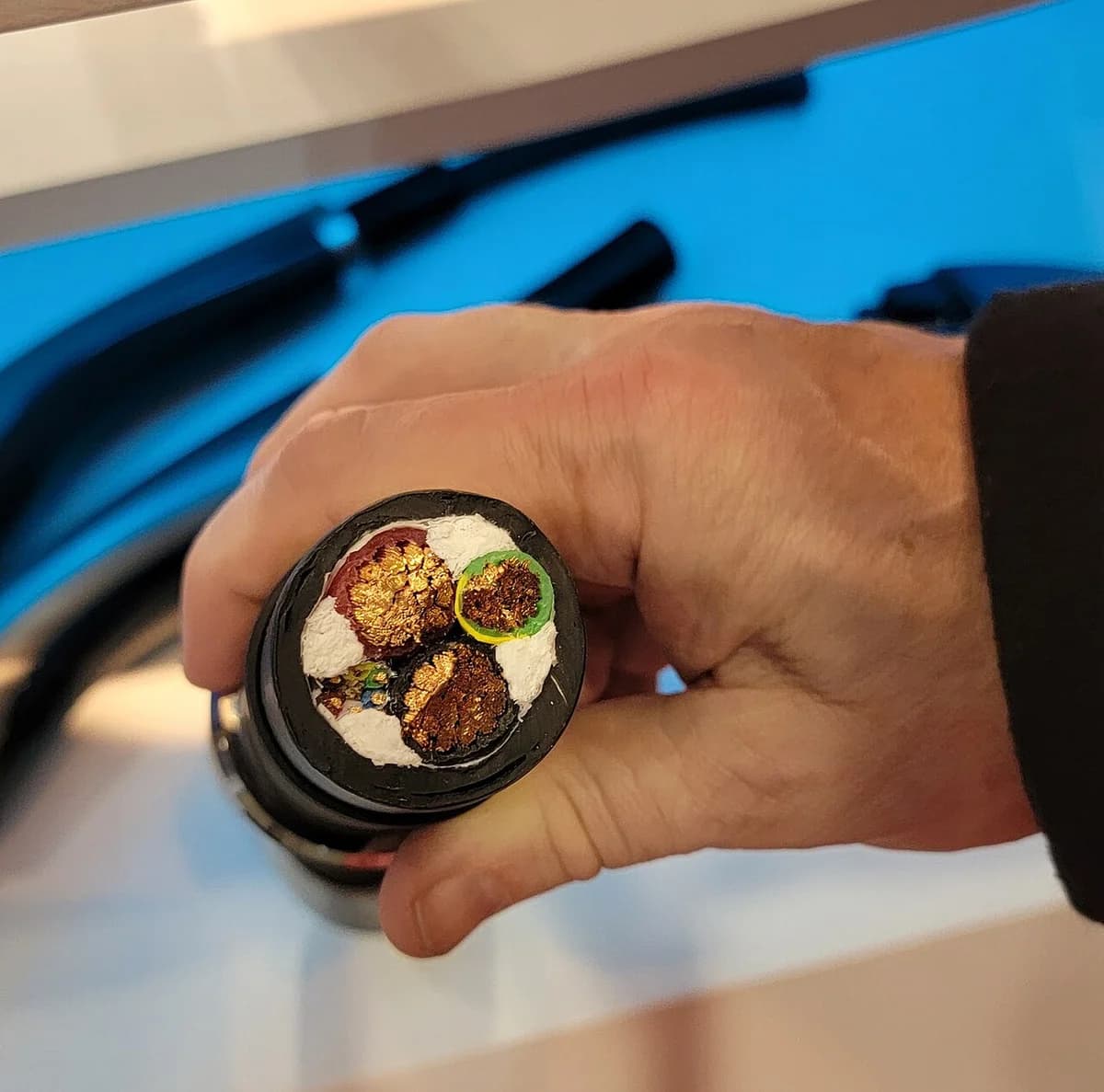 Cross-section of an electric vehicle charging cable held in hand