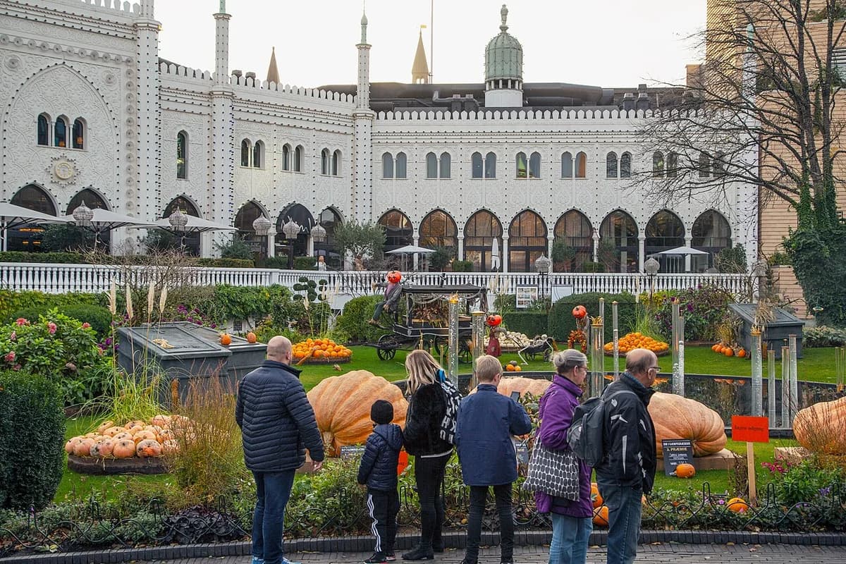 A family looks at giant pumpkins in a Halloween display at Tivoli Gardens.