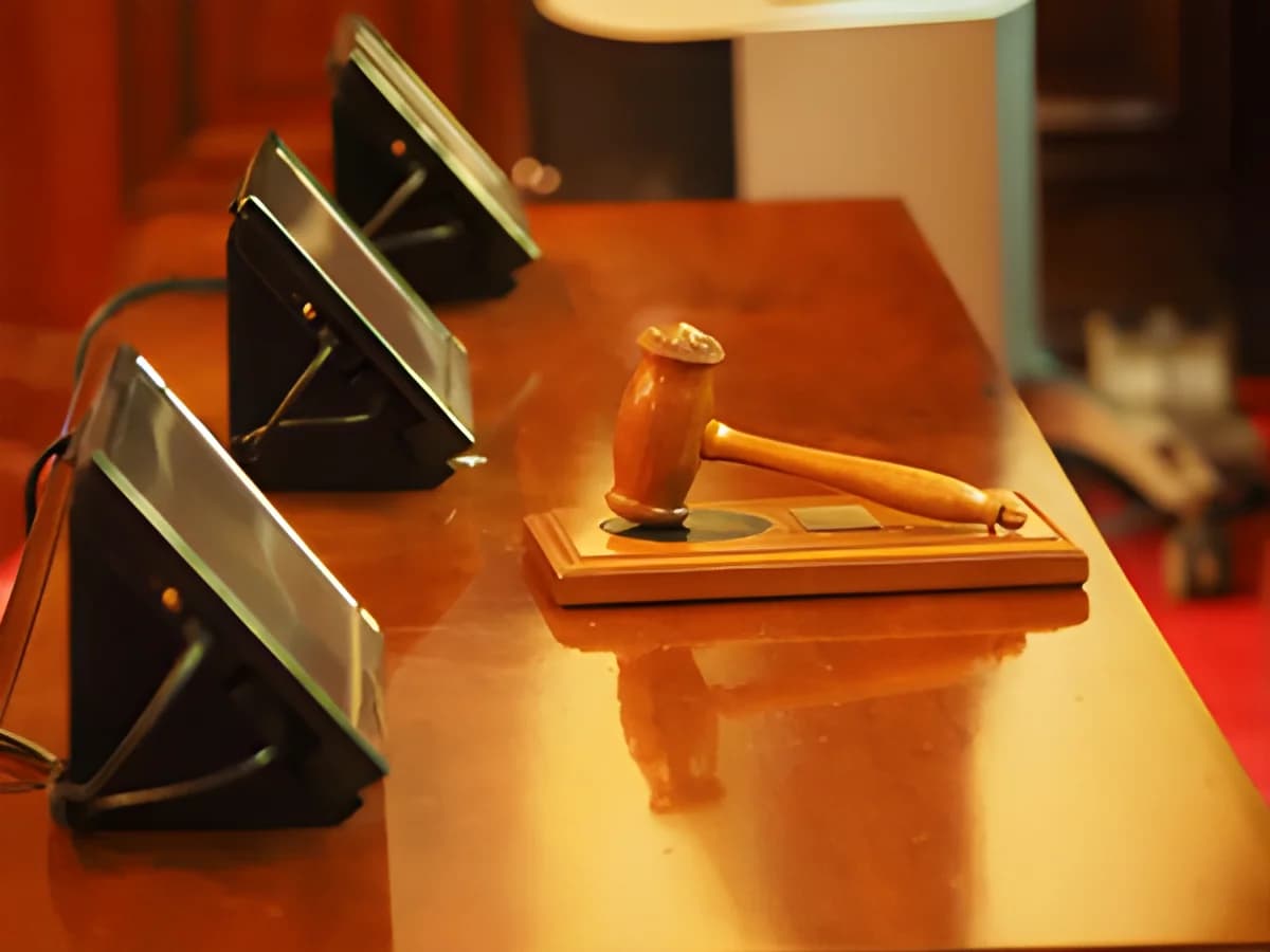 wooden judge's gavel on conference table with electronic devices