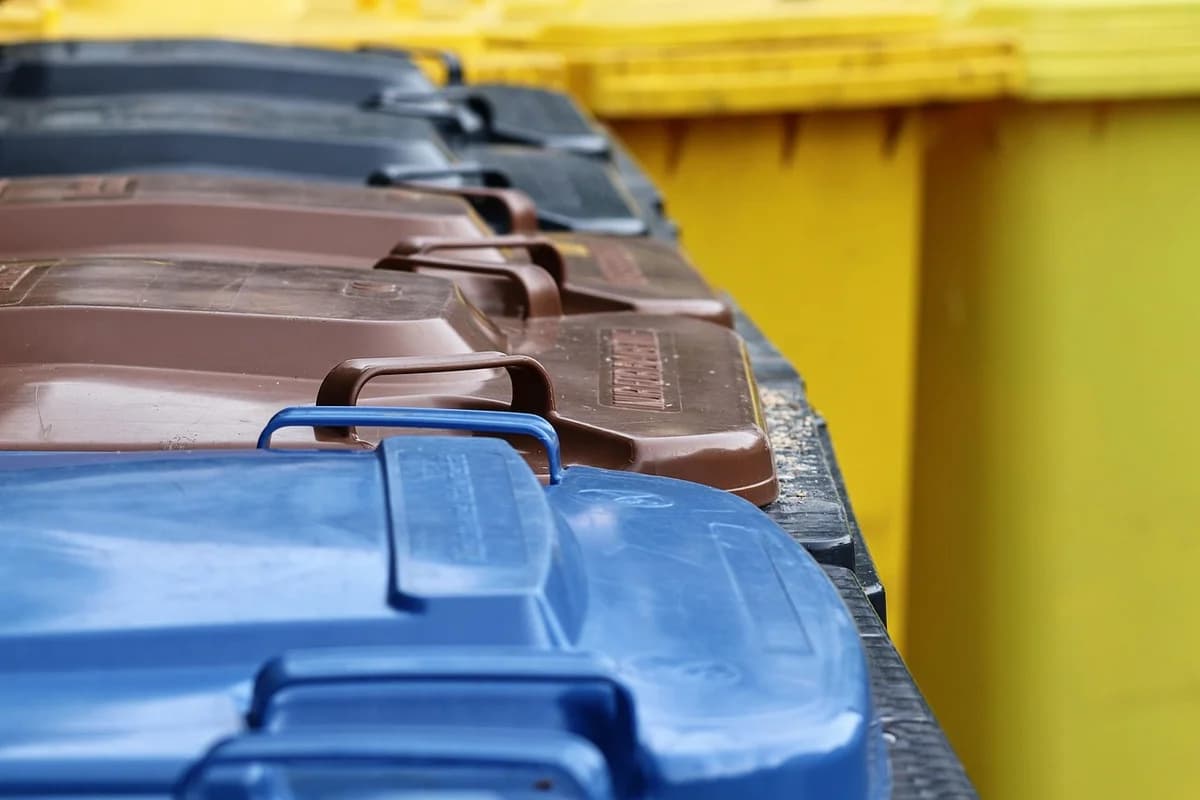Row of colored waste bins for sorting household waste.
